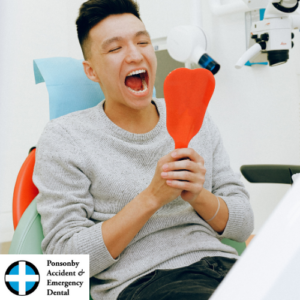 Young man sitting in a dental chair opening his mouth looking into a mirror. Saliva